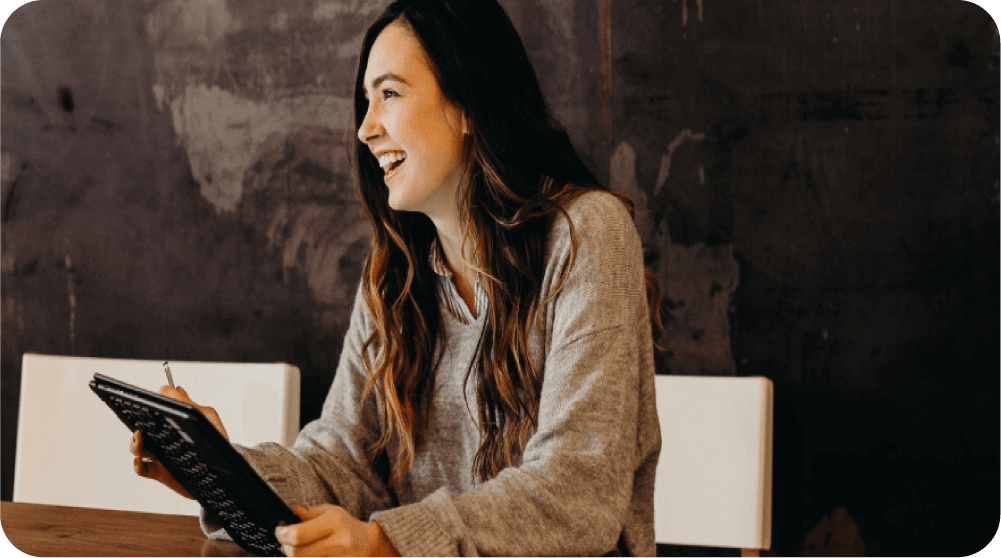 Woman holding and Ipad and smiling